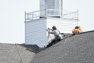 wood siding repairs with two contractors on roof of church wood siding repairs with two contractors on roof of church
