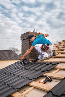 ace roofing contractor works around chimney in metal roof installation over wood underlayment ace roofing contractor works around chimney in metal roof installation over wood underlayment